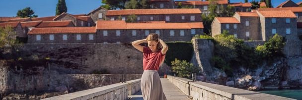 BANNER, LONG FORMAT Woman tourist on background of beautiful view of the island of St. Stephen, Sveti Stefan on the Budva Riviera, Budva, Montenegro. Travel to Montenegro concept. - Foto, Bild