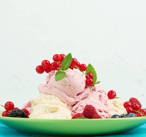 Vanilla and raspberry ice cream scoops on a round green plate - Fotoğraf, Görsel