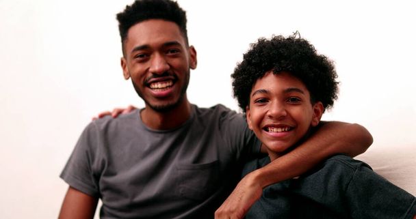 Two brothers together smiling. Black mixed race siblings, older and younger brother - Fotó, kép
