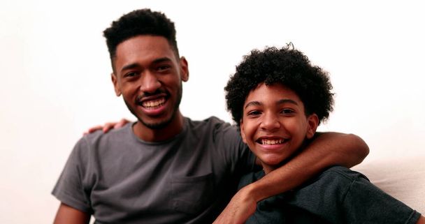 Two brothers together smiling. Black mixed race siblings, older and younger brother - Fotó, kép