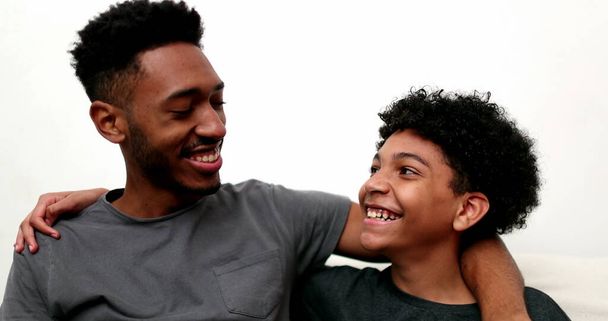 Two brothers relationship laughing and smiling together. Older and younger siblings bonding - Fotó, kép
