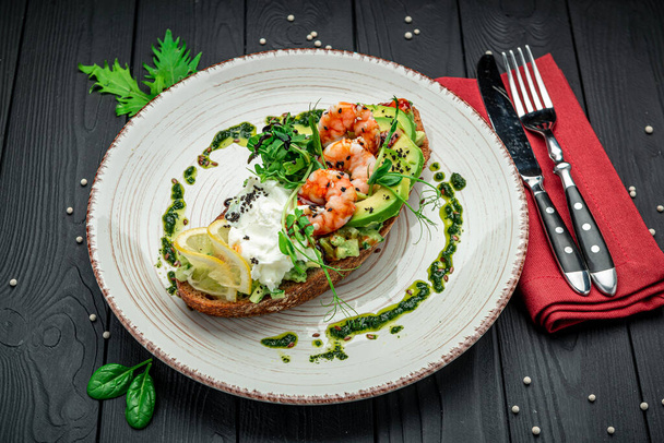 Bruschetta with shrimp, guacamole, cream cheese and pesto sauce. Healthy and wholesome food. Serving food in a restaurant. Photo for the menu. - Foto, Bild