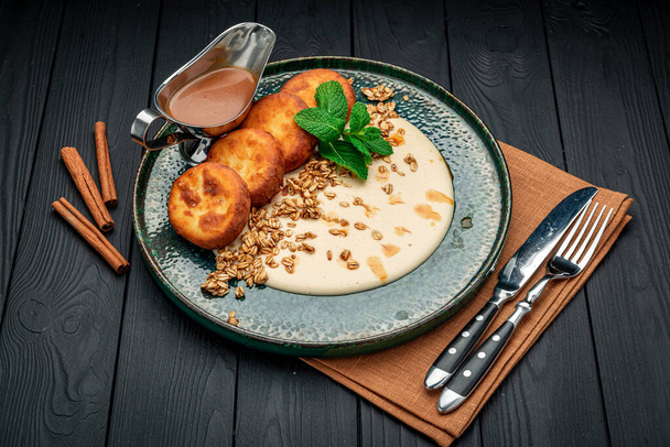 Homemade Cottage Cheese Pancakes with sweet sauce and granola. Healthy and wholesome food. Serving food in a restaurant. Photo for the menu. - Fotoğraf, Görsel