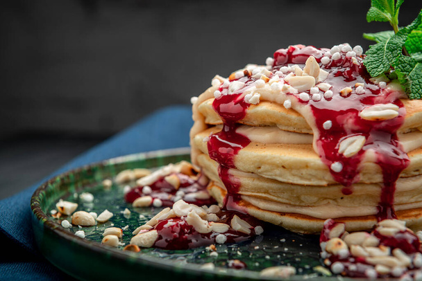 Pancake tower with yogurt, nuts and cherry jam. Healthy and wholesome food. Serving food in a restaurant. Photo for the menu. - Valokuva, kuva