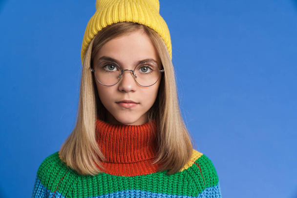 White girl wearing eyeglasses posing and looking at camera isolated over blue background - Fotografie, Obrázek
