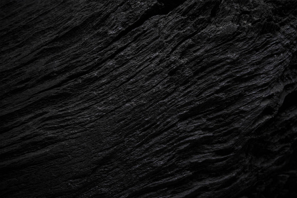 Texture of black old wood. Close-up of the texture of deep black bog oak. Sinuous wood texture with shadow - Foto, Imagem