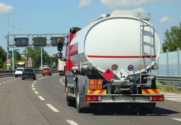 Tanklastzug für den Transport von brennbarem Material fährt schnell auf der Autobahn mit Fahrzeugverkehr - Foto, Bild