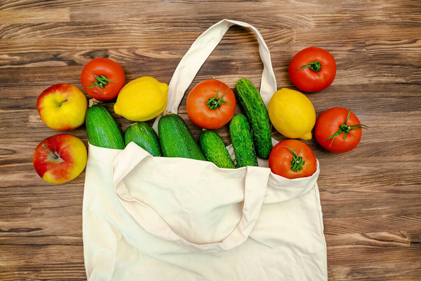 Detox diet fitness vegetarian vegan healthy food for dinner,proper nutrition with fresh fruits and vegetables in eco bag on wooden background top view copy space flatly flat lay.Set of autumn harvest. - 写真・画像