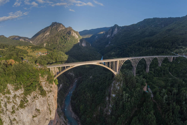Famoso ponte sul fiume Tara in Montenegro o Crna gora al sole della sera, chiamato djurdjevic. . Ponte colossale che si estende sul fiume Tara, archi in cemento che attraversano l'arco. - Foto, immagini