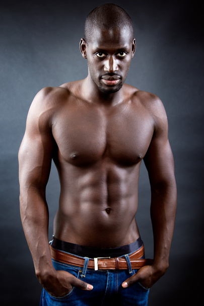 Beautiful and muscular man in dark background.  - Photo, image