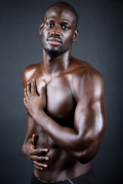 Beautiful and muscular man in dark background.  - Фото, изображение