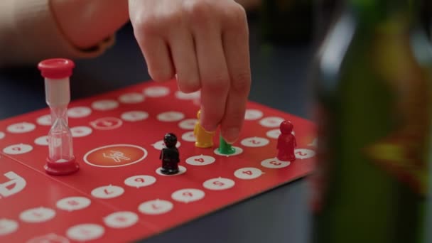 Young people playing charades board games with figurines, rolling dices for cards game. Men and women enjoying strategy competition to guess card for entertainment and fun. Close up. - Footage, Video