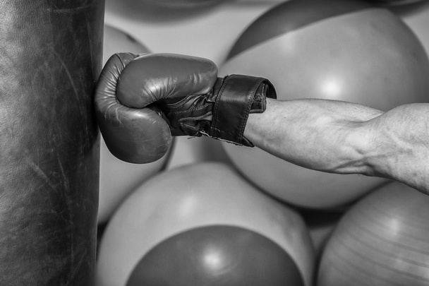 Hombre con guantes de boxeo golpeó un saco de boxeo
 - Foto, imagen