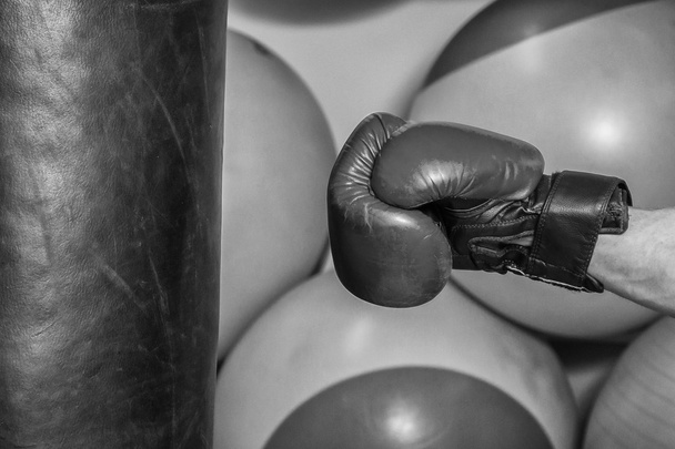 Hombre con guantes de boxeo golpeó un saco de boxeo
 - Foto, Imagen
