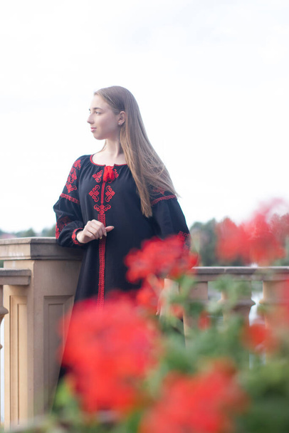 portrait of young woman wearing black and red vyshyvanka. national embroidered Ukrainian shirt. girl in dress outdoors in park. summer. - Foto, Bild