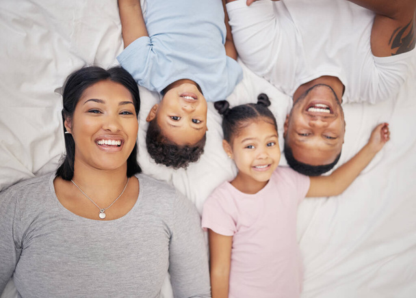 Happy mixed race family relaxing together and bonding at home from above. Little brother and sister spending time with their parents. - Φωτογραφία, εικόνα