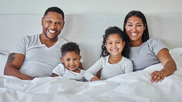 una hermosa familia joven hablando y uniéndose en la cama juntos. - Foto, imagen