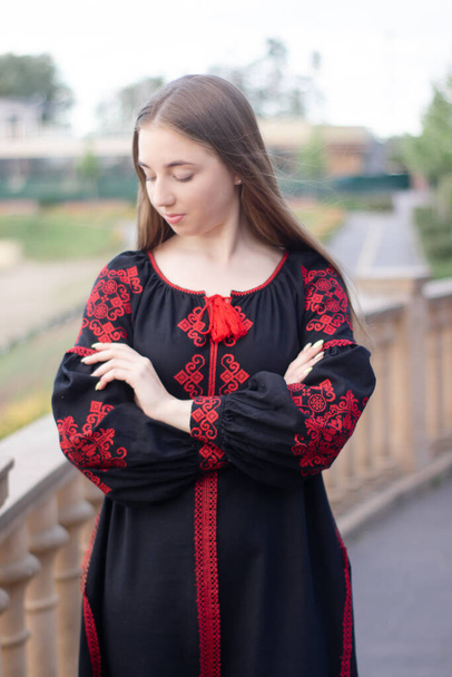portrait of young woman wearing black and red vyshyvanka. national embroidered Ukrainian shirt. girl in dress outdoors in park. summer. - Fotografie, Obrázek