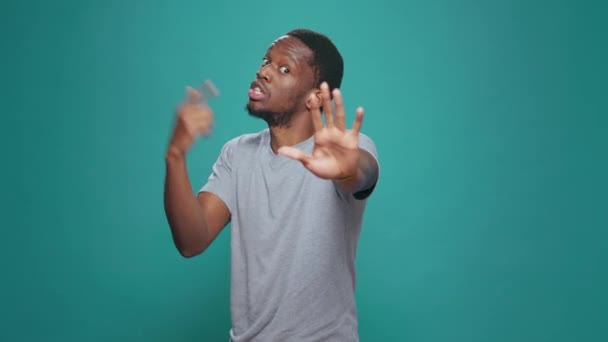Portrait of person doing talk to the hand rejection gesture, expressing refusal and disapproval. Negative man advertising no sign and disagreeing, showing dislike symbol in studio. - Séquence, vidéo