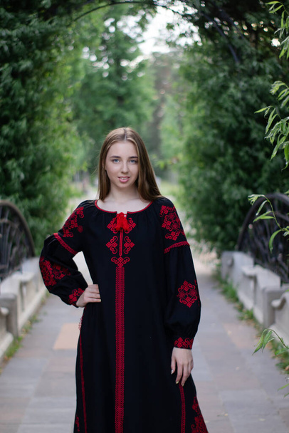 portré fiatal nőről, fekete-piros vyshyvankában. Országos hímzett ukrán ing. lány ruha szabadban a parkban. nyár. - Fotó, kép