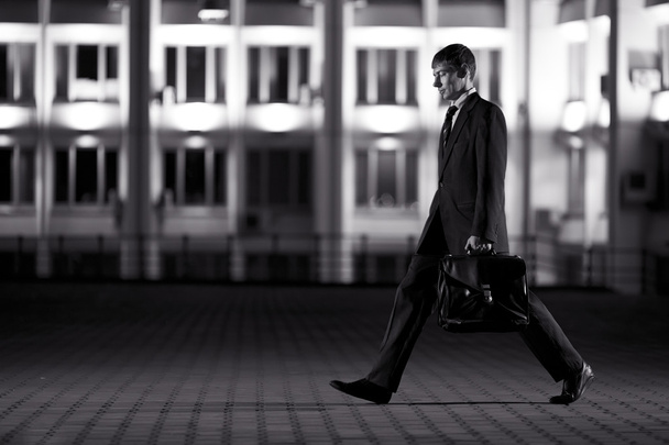 Handsome businessman with briefcase at night city in the backgro - Foto, Imagem