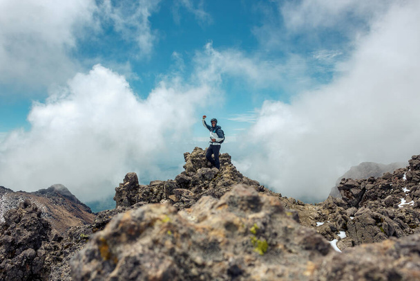 Молодий чоловік з рюкзаком стоїть на вершині гори в мексиці
 - Фото, зображення