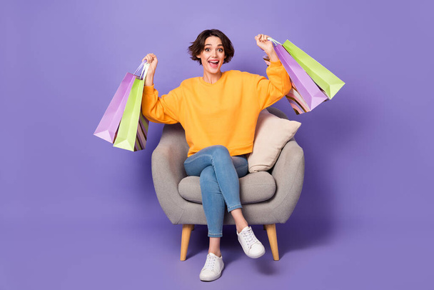 Portrait of attractive cheerful girl holding bags rejoicing having fun isolated over violet lilac color background. - Fotoğraf, Görsel