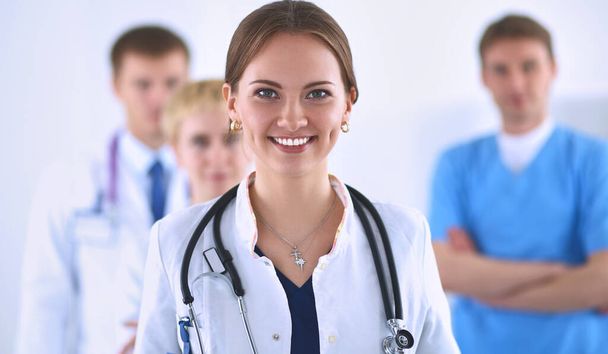 Attractive female doctor in front of medical group . - Foto, Imagen