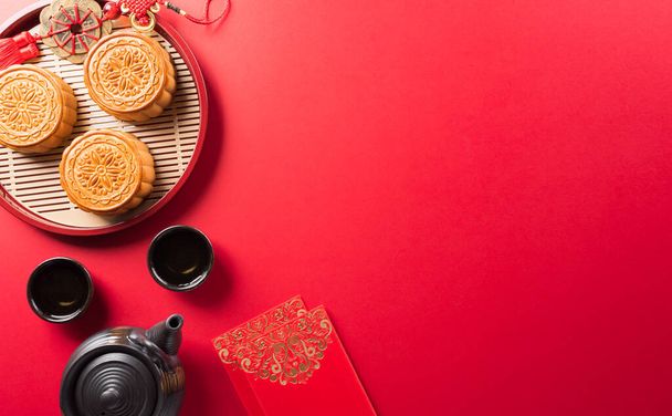 Chinees Mid-Autumn Festival concept gemaakt van maankoeken, thee en pruimenbloesem. Chinese karakters FU in het artikel verwijzen naar geluk, rijkdom, geldstroom. - Foto, afbeelding