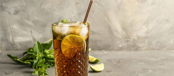 Glass of tasty Cuba Libre cocktail on grey background with space for text - Фото, зображення