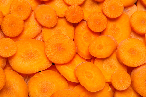 Slices of fresh carrots as background, closeup - 写真・画像