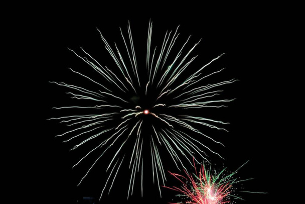 A beautiful view of a glowing Firework in the dark clear sky - 写真・画像