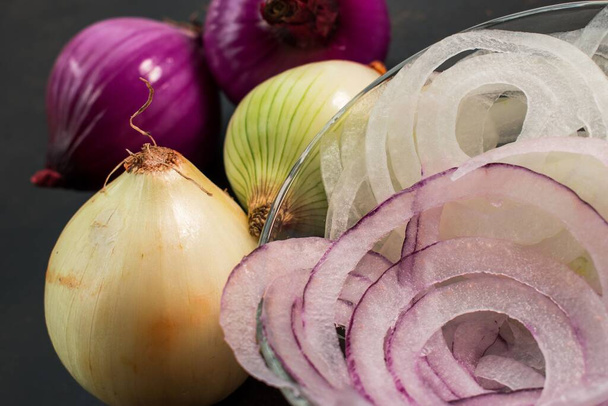 A closeup of colorful onions half sliced and half whole - Photo, Image