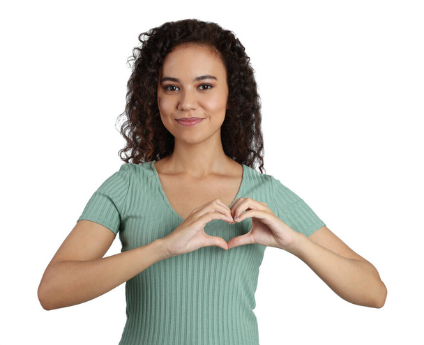 Happy young African-American woman making heart with hands on white background - Фото, изображение
