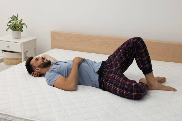 Happy man on bed with comfortable mattress at home - Photo, Image
