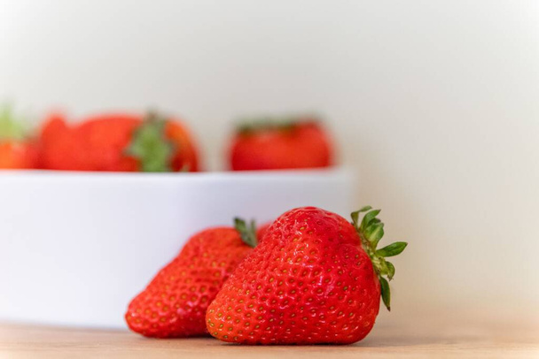 A selective focus shot of strawberries on a white background - 写真・画像