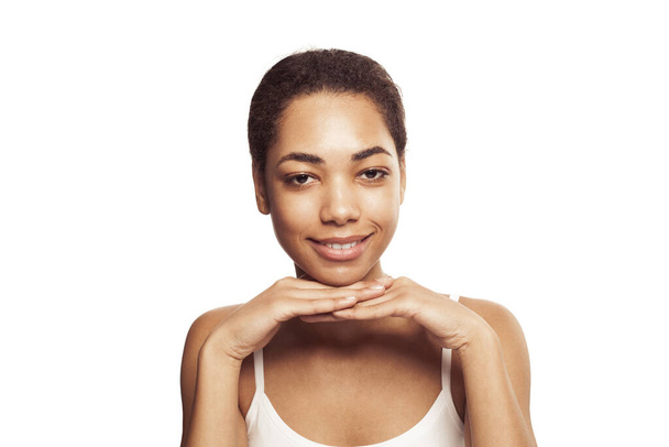 Schönheit. Lächelnde schwarze Frau mit perfekt sauberer Haut und natürlichem Make-up Porträt. Schöne glückliche afrikanisch-amerikanische Modell auf weißem Hintergrund. Wellness- und Pflegekonzept - Foto, Bild