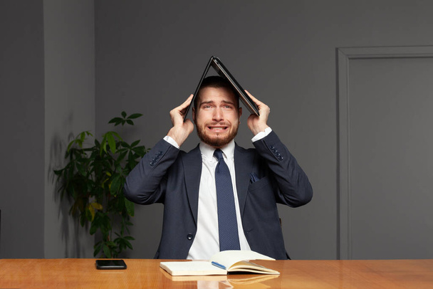 Stressaantunut nuori liikemies kannettava tietokone sisätiloissa toimistossa - Valokuva, kuva
