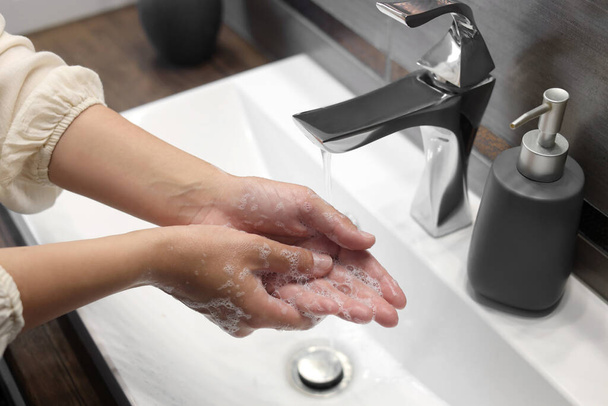 Woman washing hands in bathroom, closeup view - Фото, зображення