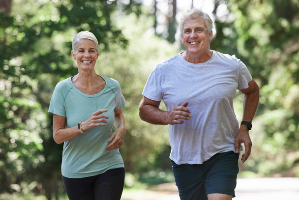 a mature couple running together outdoors. - Foto, imagen