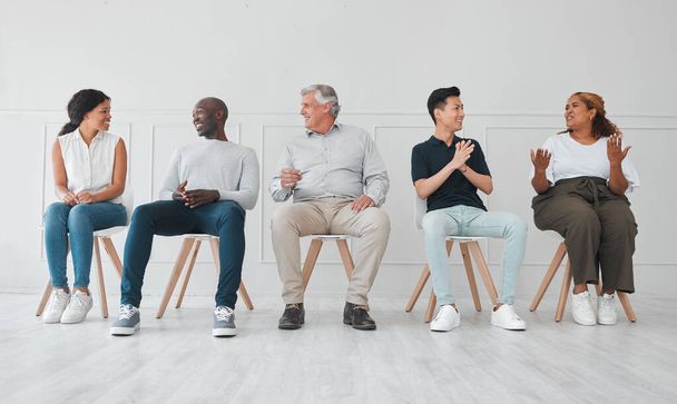 a group of diverse people talking to each other while sitting in line against a white background. - Foto, afbeelding