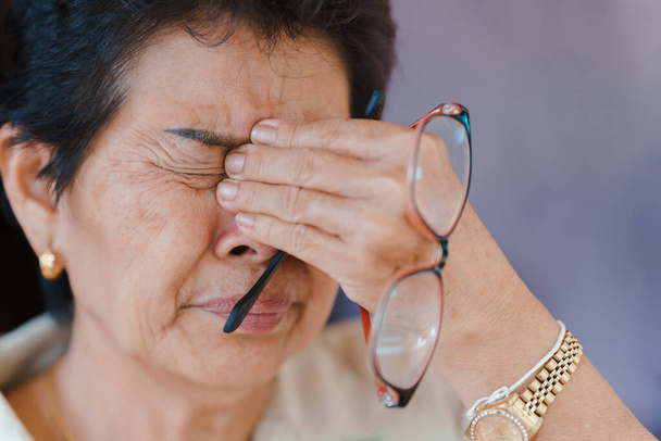 Starší ženy s onemocněním oka způsobujícím velkou bolest v očích. Koncepce zdravotních problémů u starších pacientů. - Fotografie, Obrázek