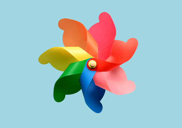 Bright pinwheel toy with colorful curls whirling against blue background in summer - Photo, Image