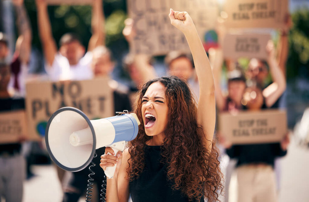 Egy fiatal nő kiabál egy hangosbemondóba tiltakozás közben.. - Fotó, kép