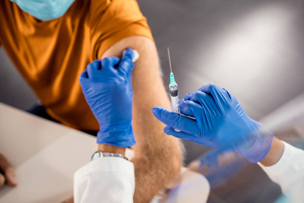 Close-up of senior man receiving a vaccine in the hospital.  - Photo, Image