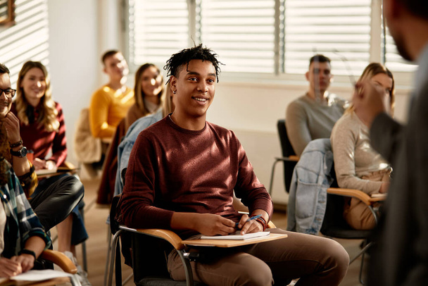 Щасливий чорний студент слухає лекцію в класі в університеті
. - Фото, зображення