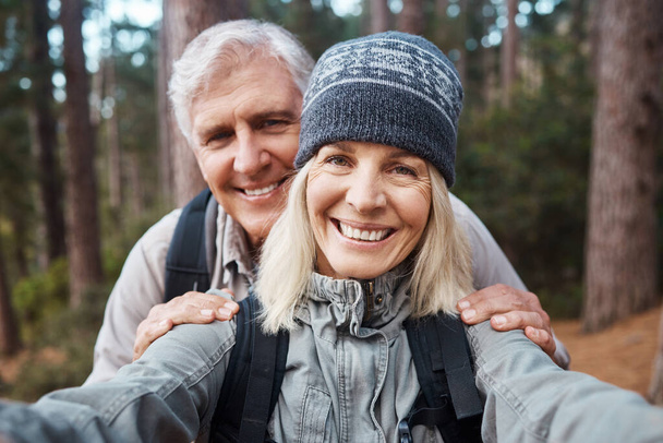 a senior couple taking a selfie while out hiking together. - Foto, imagen
