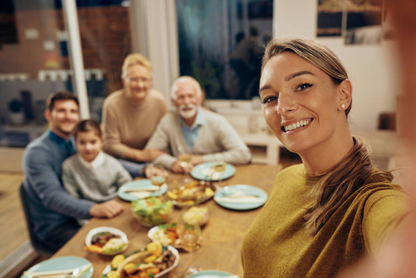 Happy family and her extended family taking selfie during lunch at home. - 写真・画像