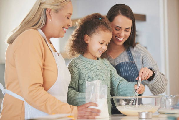a little girl baking with her mother and grandmother at home. - Photo, Image