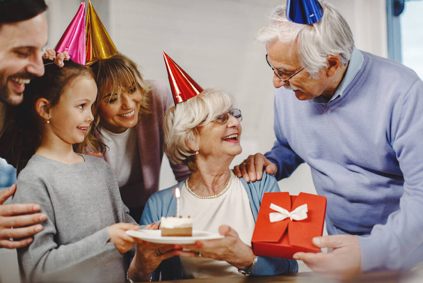 Happy senior woman celebrating Birthday with her multi-generation family at home.  - 写真・画像
